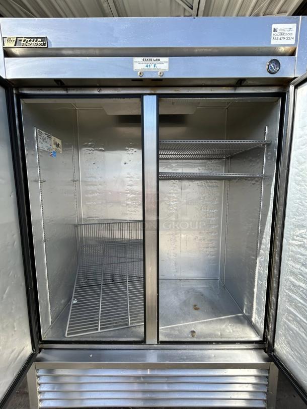 True TS-49-HC stainless steel refrigerator, excellent condition, features two solid doors, spacious interior with wire racks, tested and working.