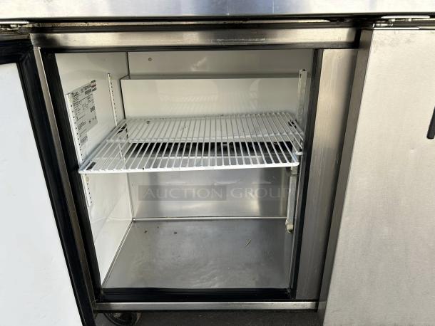 True TSSU-72-18-HC refrigerated sandwich prep table, 72 3/8", excellent condition, stainless steel, open door showing shelves.