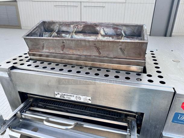 Duke FBB-NC-120 gas conveyor toaster oven in excellent condition. Stainless steel, 43"W x 30"D x 53"H, natural gas, 120V, caution label visible.