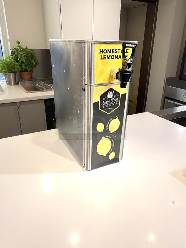 Newco FPM-1 stainless steel cold beverage dispenser, manual pour, excellent condition, "Homestyle Lemonade" label.