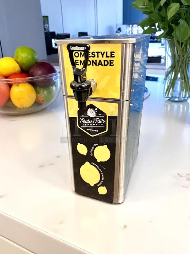 Newco FPM-1 stainless steel cold beverage dispenser in excellent condition, manual pour, fully tested, with lemonade label.