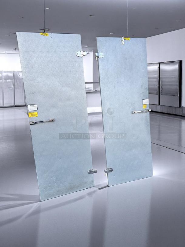 Norlake walk-in cooler double doors with heavy-duty insulated panels. Fully tested. Visible labels indicate safety and usage instructions.