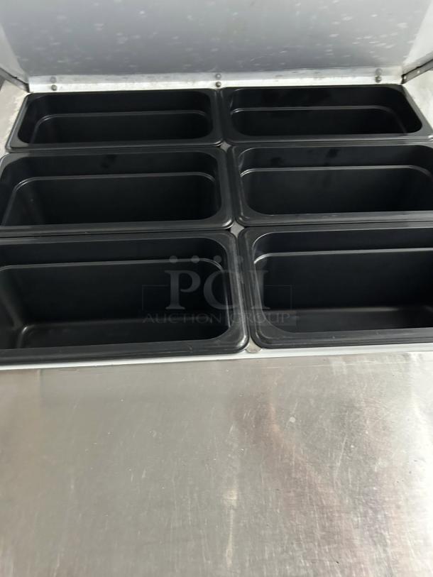 Continental Refrigerator SW60-24M prep unit, stainless steel top with six black containers, in excellent working condition.