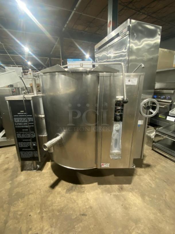 Commercial stainless steel tilting steam kettle with swing spout faucet, natural gas powered, on legs, excellent condition.