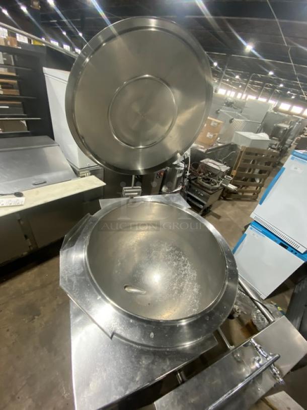 Commercial stainless steel natural gas tilting steam kettle with swing spout faucet on legs, open lid shown.