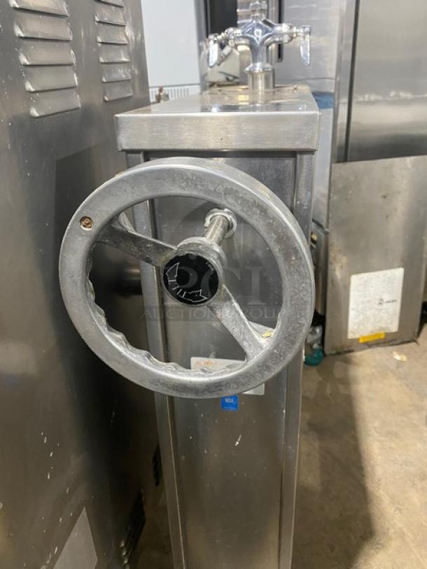 Commercial stainless steel tilting steam kettle, natural gas powered, with swing spout faucet, on legs.