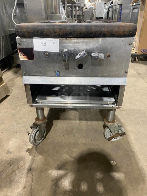 Commercial stainless steel single burner stock pot range, natural gas powered, with casters. Some wear visible.