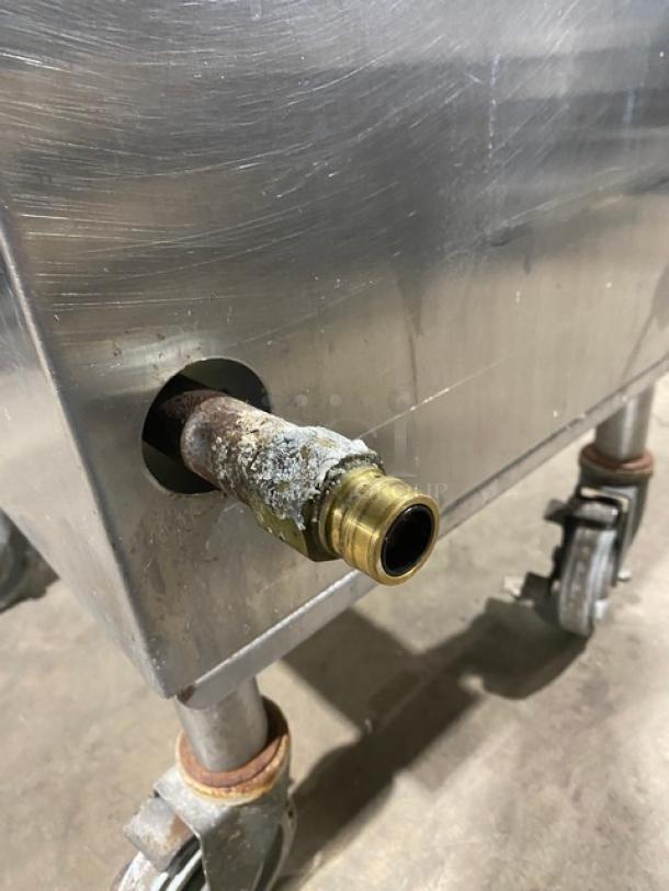 Commercial stainless steel natural gas single burner stock pot range on casters. Visible wear on connector.