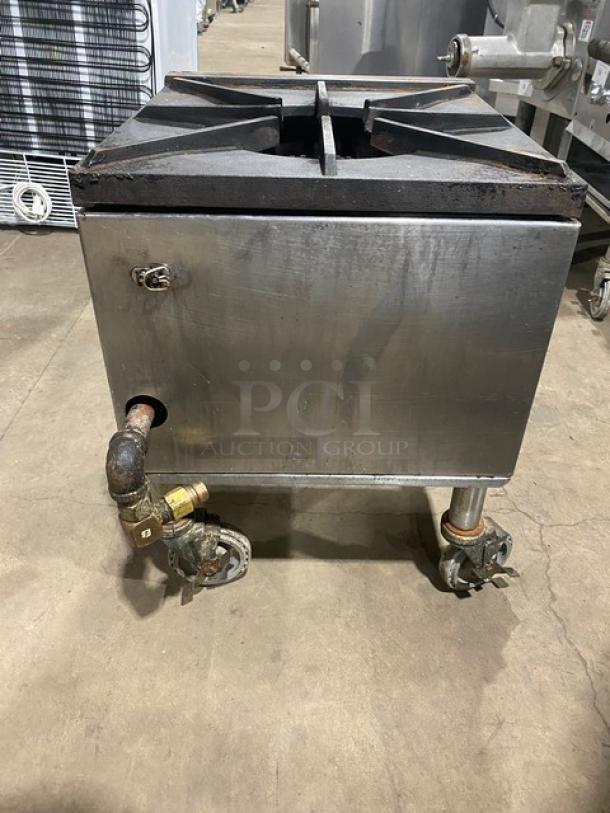 Commercial stainless steel gas-powered single burner stock pot range on casters; used condition with visible wear.