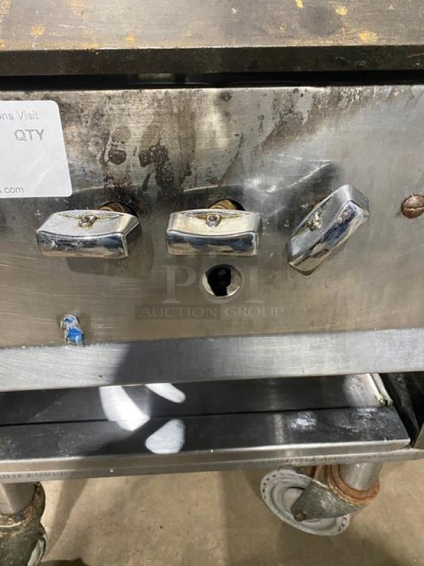 Commercial stainless steel single burner stock pot range on casters, natural gas powered, durable, with control knobs.