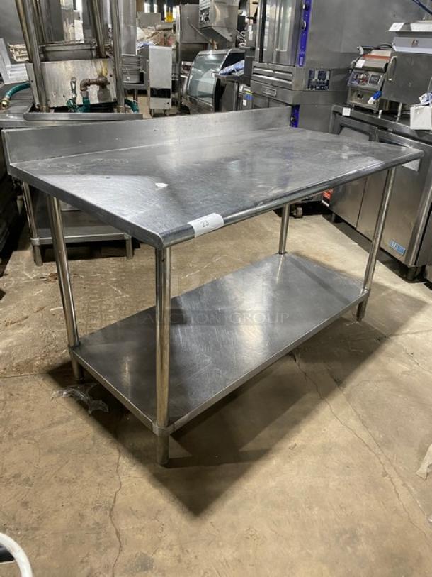 Commercial stainless steel worktop table with undershelf, up-turned backsplash, used condition, durable construction.