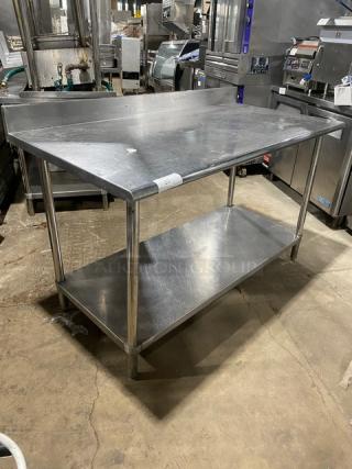 Commercial stainless steel worktop table with undershelf, up-turned backsplash, used condition, durable construction.