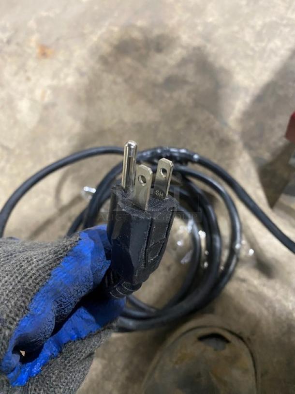 American Eagle AE-G22NM motor unit plug, black cord coiled on concrete floor, electrical prong details visible.