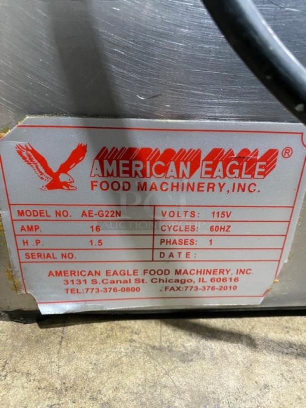 American Eagle stainless steel electric bench meat grinder, model AE-G22N, 115V, 1 phase. Label shows specs and contact info.