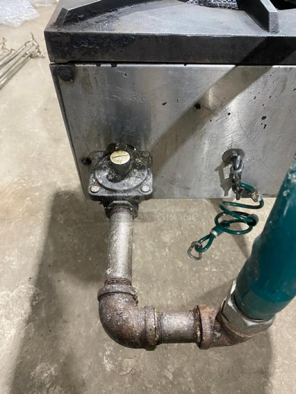 U.S. Range commercial stainless steel single burner stock pot range on legs with natural gas connection hose. Visible wear.