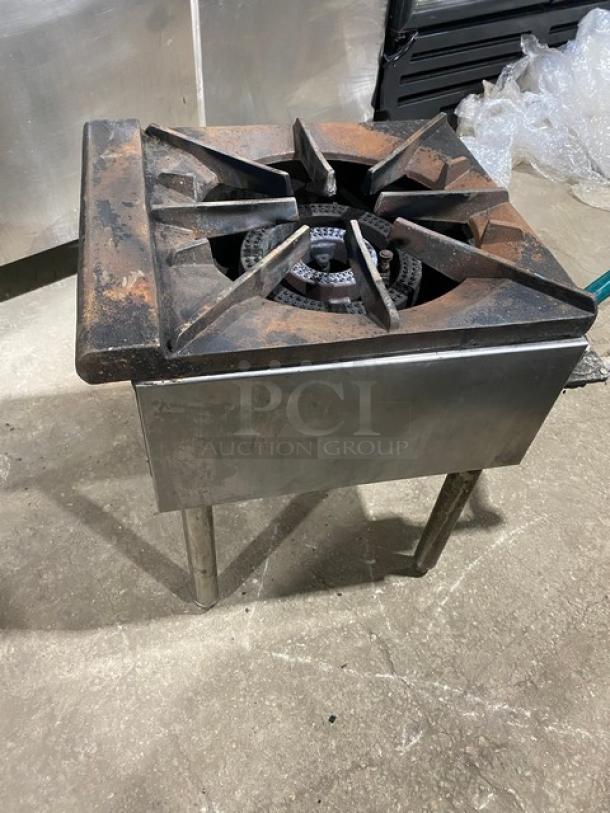 U.S. Range stainless steel single burner stock pot range, natural gas powered, with gas connection hose, on metal legs. Slight wear visible.