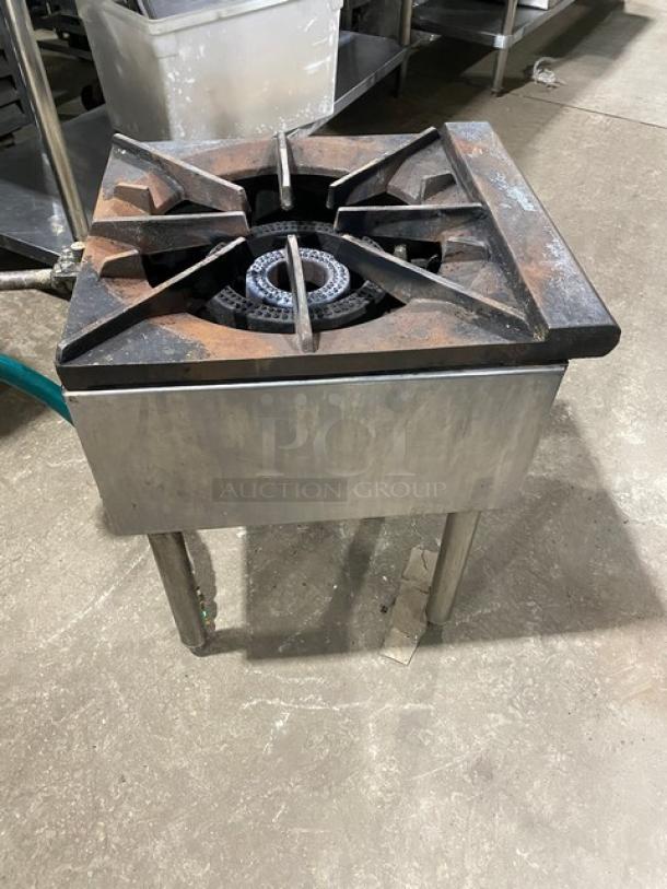 U.S. Range stainless steel natural gas single burner stock pot range with gas connection hose, on legs, shows signs of use.