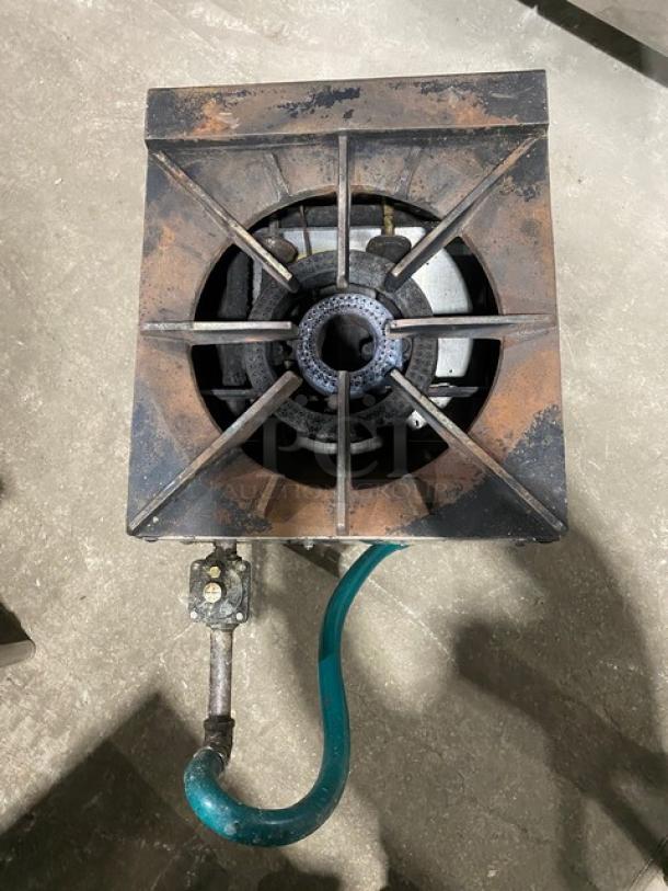 U.S. Range stainless steel natural gas single burner stock pot range with gas hose, mounted on legs, shows moderate wear.