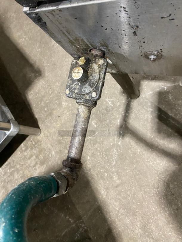 U.S. Range stainless steel single burner stock pot range with gas connection hose, shown on sturdy legs. Visible wear on metal.