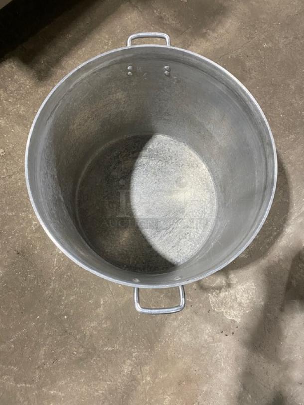 Heavy duty commercial round stock pot with side handles, large capacity, visible wear inside, metallic finish.