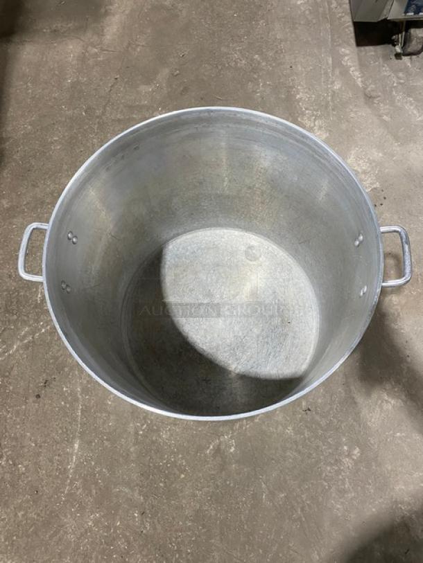 Commercial heavy-duty round stock pot with handles, metal, large capacity, slightly worn inside, ideal for professional kitchens.