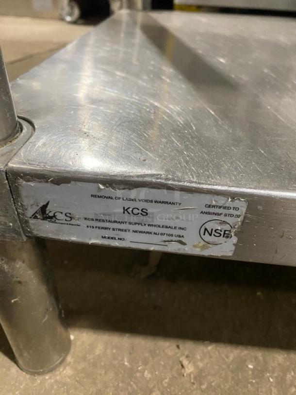 KCS commercial stainless steel worktop table with undershelf, up-turned backsplash, and legs. Label shows NSF certification.
