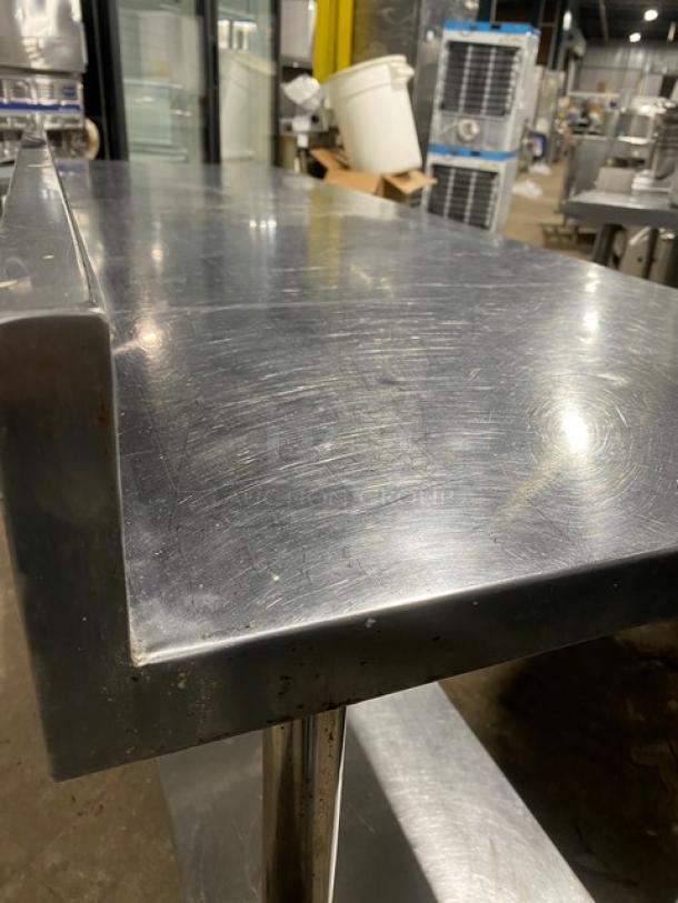 KCS stainless steel worktop table with undershelf and up-turned backsplash, on legs. Used, with surface wear visible.