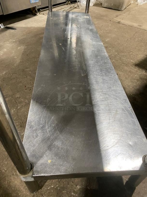 KCS stainless steel worktop table, single undershelf, up-turned backsplash, on legs. Used condition with visible scratches.
