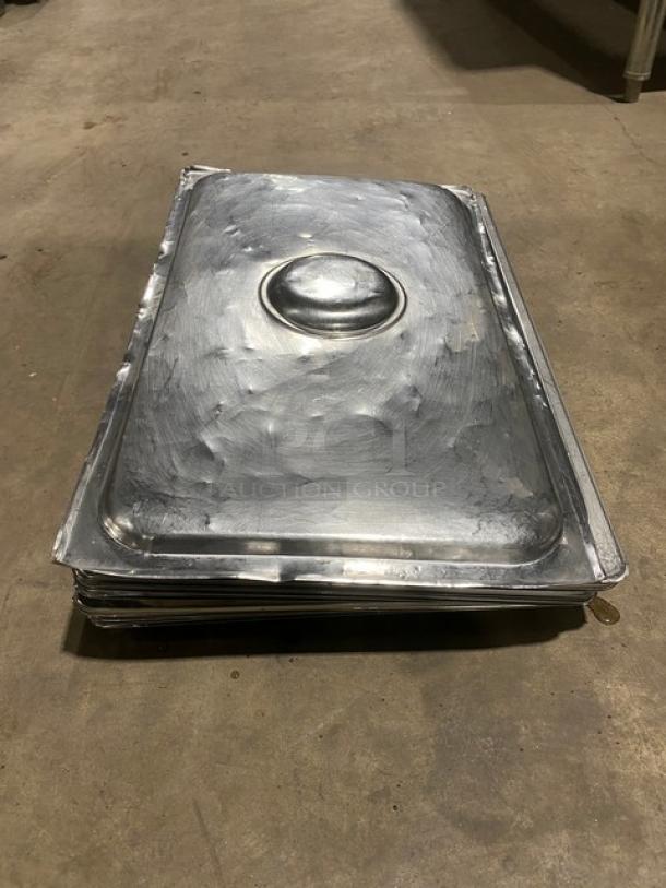 Stainless steel steamtable pan lid, rectangular, with center handle. Used condition with visible wear. Suitable for commercial use.