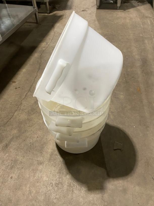 Commercial white round food storage containers with handles, stacked. Durable plastic, suitable for multiple uses.