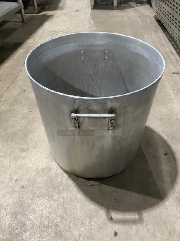 Heavy duty commercial round stock pot with sturdy handles, showing signs of wear. Ideal for large-scale cooking operations.