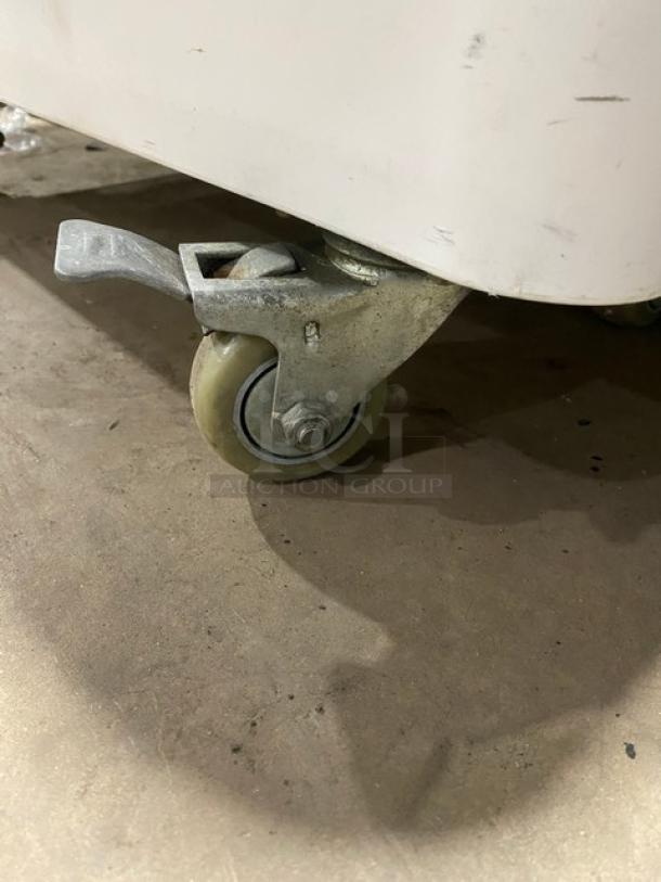 Commercial white portable food ingredient bin with clear lid and caster wheel for mobility. In used condition.