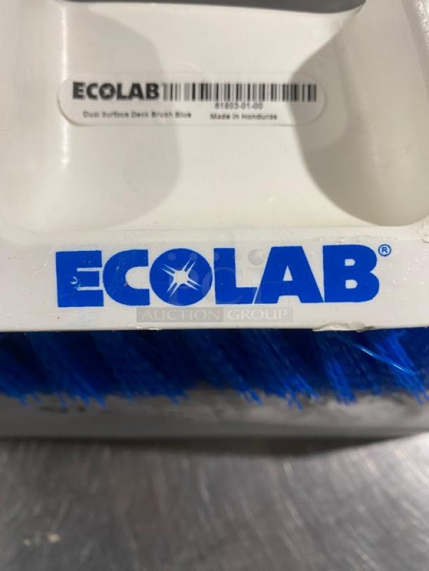 Ecolab dual surface deck brush, white with blue bristles, new condition. Label reads "Dual Surface Deck Brush Blue," made in Honduras.
