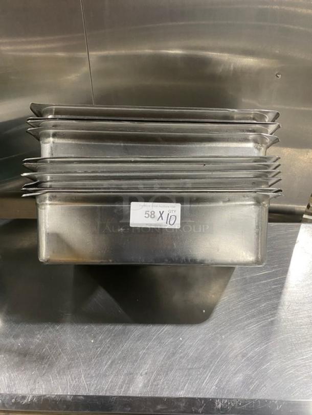 Stainless steel hotel steamtable pans, stack of 10, used condition, label reads "58 X 10". Ideal for commercial use.