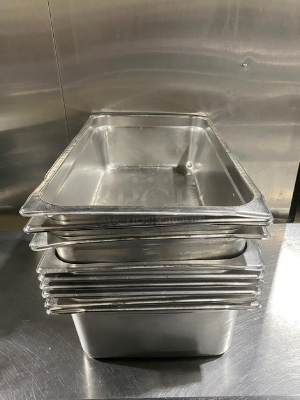 Stack of stainless steel hotel pans, commercial-grade, used condition. Ideal for steam tables. Ten pans shown.