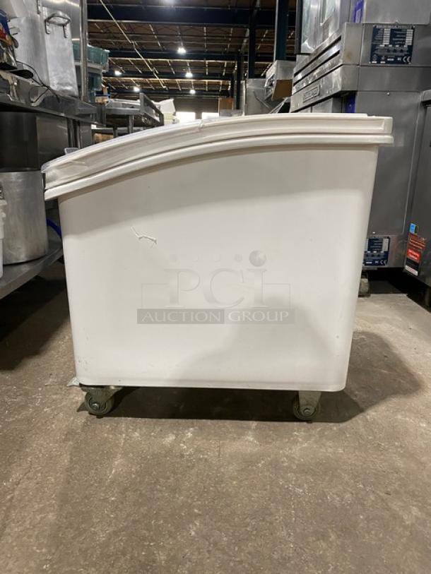 Winco commercial white portable food storage bin with clear lid, on casters, slightly worn. Ideal for kitchen use.