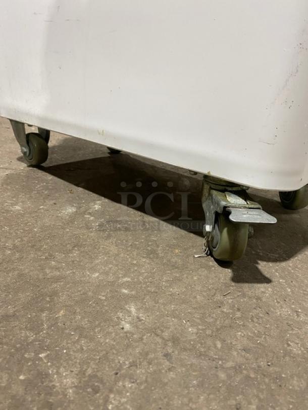 Winco commercial white storage bin with clear lid. Features casters for easy mobility. Suitable for food ingredients.