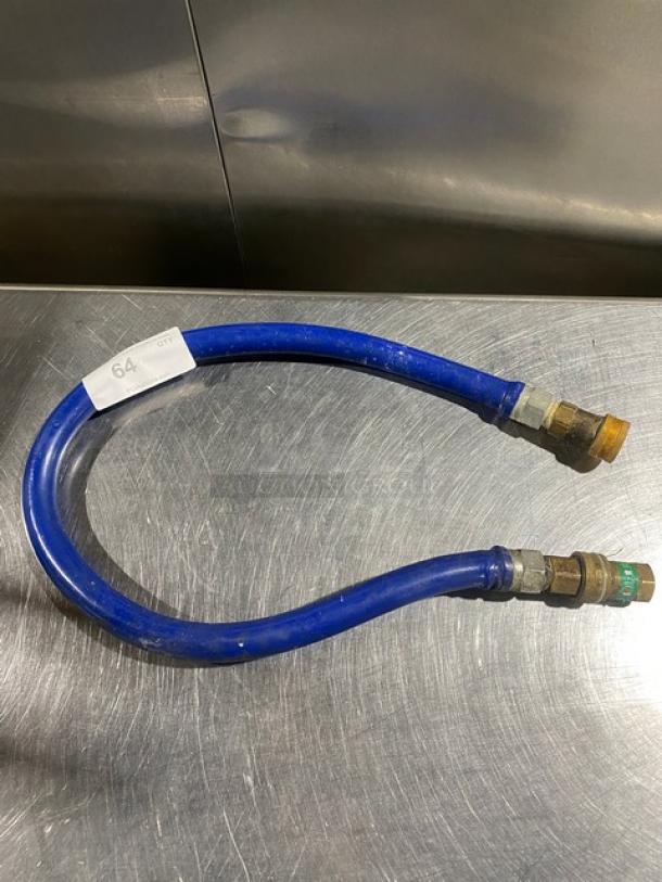 Commercial blue gas connector hose with brass fittings, in good condition. Tag labeled "64." Sturdy and flexible design.