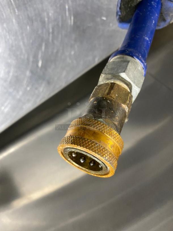 Commercial blue gas connector hose, brass fittings, metal finish, slightly worn. Ideal for secure gas connections.