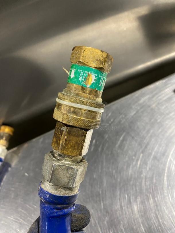 Blue commercial gas connector hose with brass fittings, wear visible, green label with usage details. Suitable for industrial use.