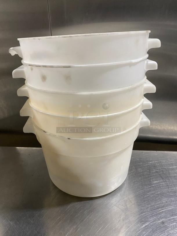Stack of five commercial white round food storage containers with handles, used condition.