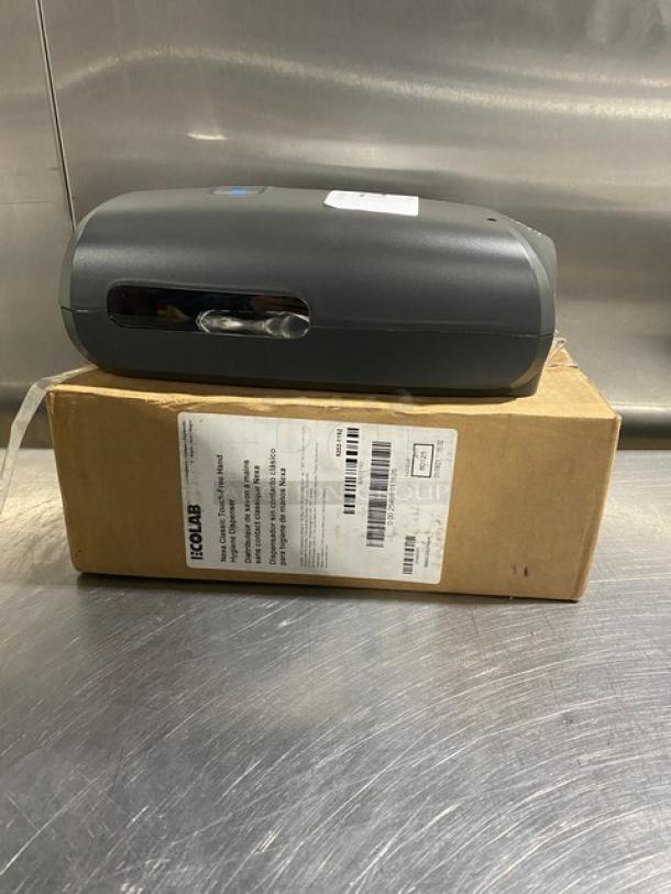 Ecolab Nexa Series touch-free hand hygiene dispenser, new in box, commercial model; labeled packaging visible.