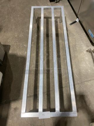 Commercial heavy-duty dunnage rack on legs, metal construction, excellent condition, label "75" visible on front.