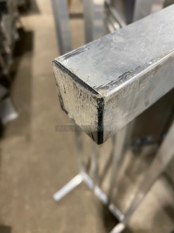 Commercial heavy-duty dunnage rack on legs, metal construction, sturdy and durable, signs of wear visible. Ideal for storage solutions.