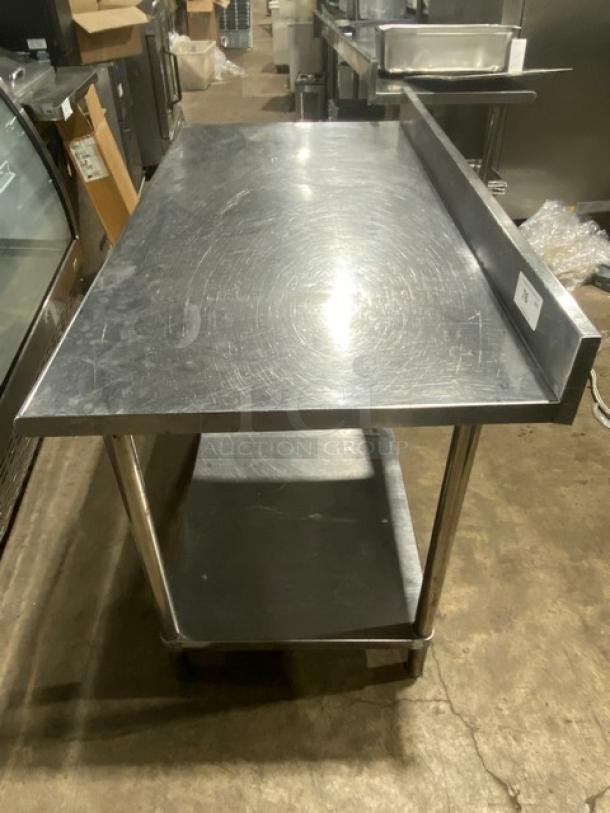 Commercial stainless steel worktop table with undershelf and up-turned backsplash, on legs. Used condition.