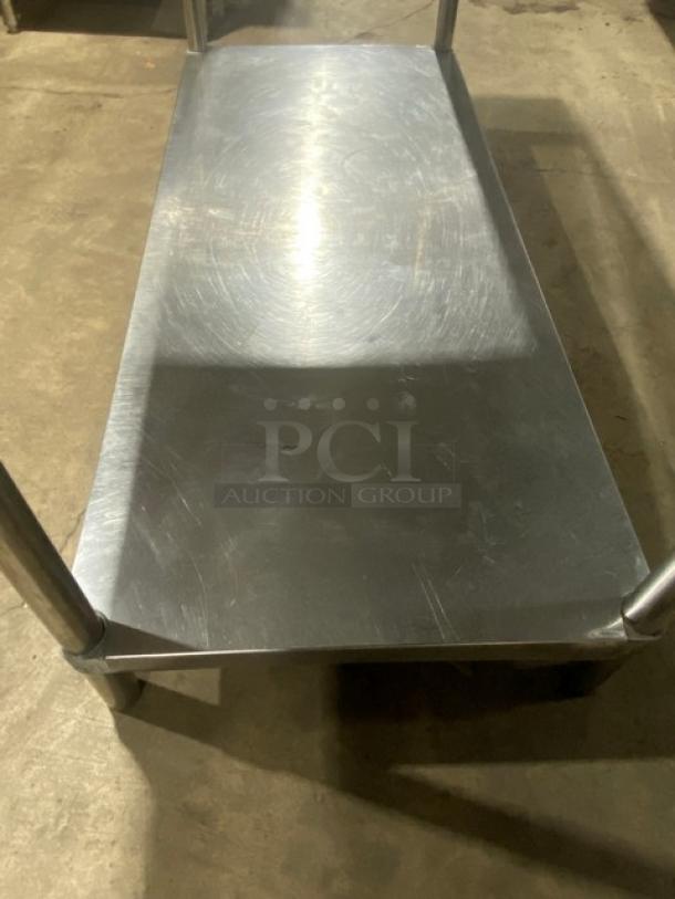 Commercial stainless steel worktop table with single undershelf, up-turned backsplash, and sturdy legs. Good condition.