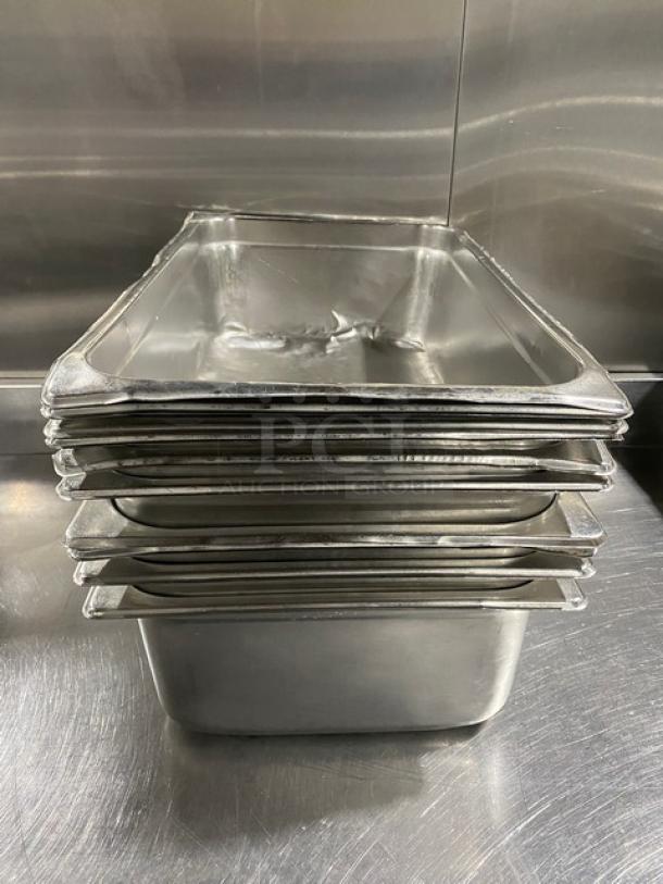 Stack of commercial stainless steel steamtable pans in used condition, showcasing durability and ideal for hotel settings.
