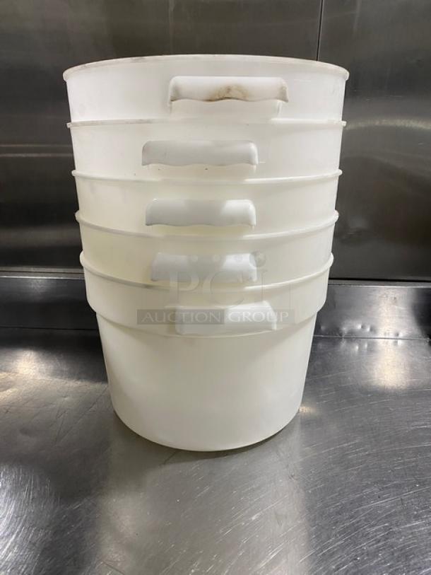 White round commercial food storage containers with handles, stackable design, used condition.