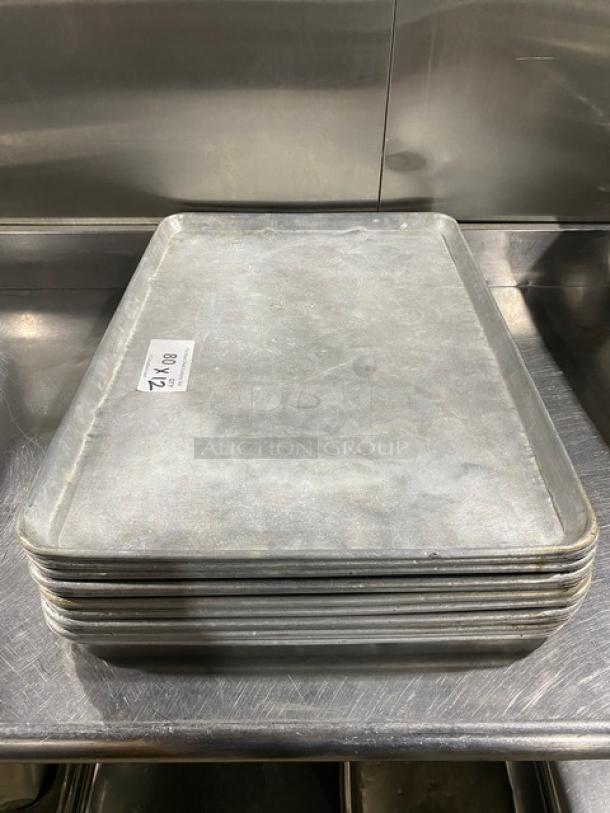 Stack of commercial baking sheet pans, slightly worn, with a visible tag reading "12X." Ideal for high-volume baking.
