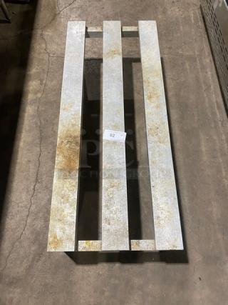 Commercial heavy-duty dunnage rack on legs, metal with visible wear, numbered tag "82". Perfect for storage use.